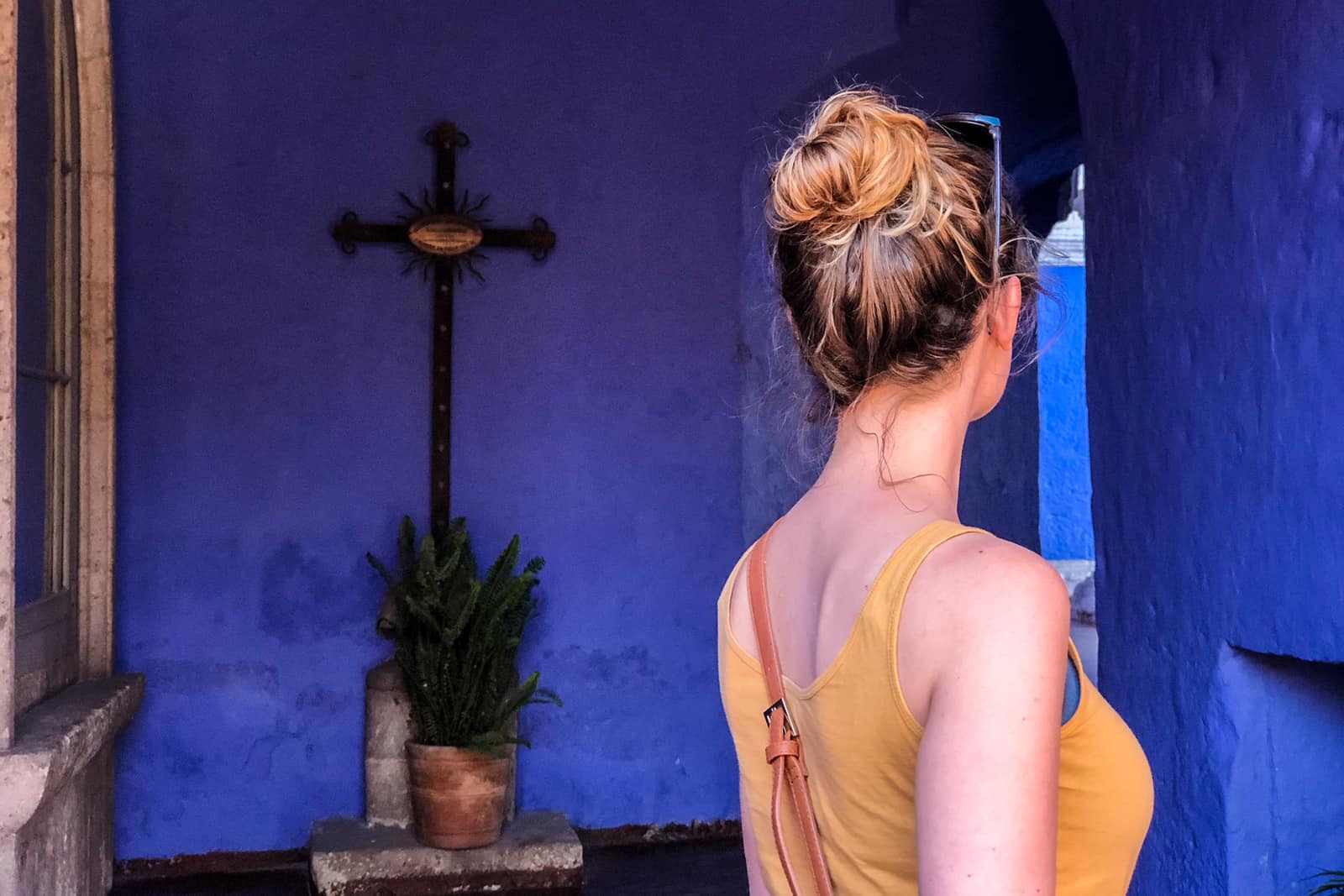 A woman enters a blue room at the Santa Catalina Convent in Arequipa while traveling in Peru.