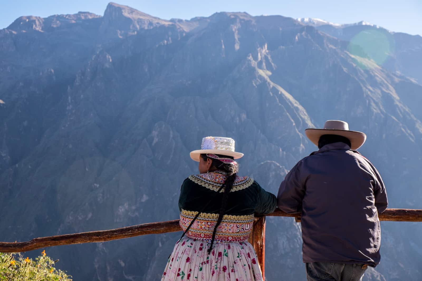 A Peruvian couple in traditional dress at a viewing point overlooking Colca Canyon near Araquipa, Peru.