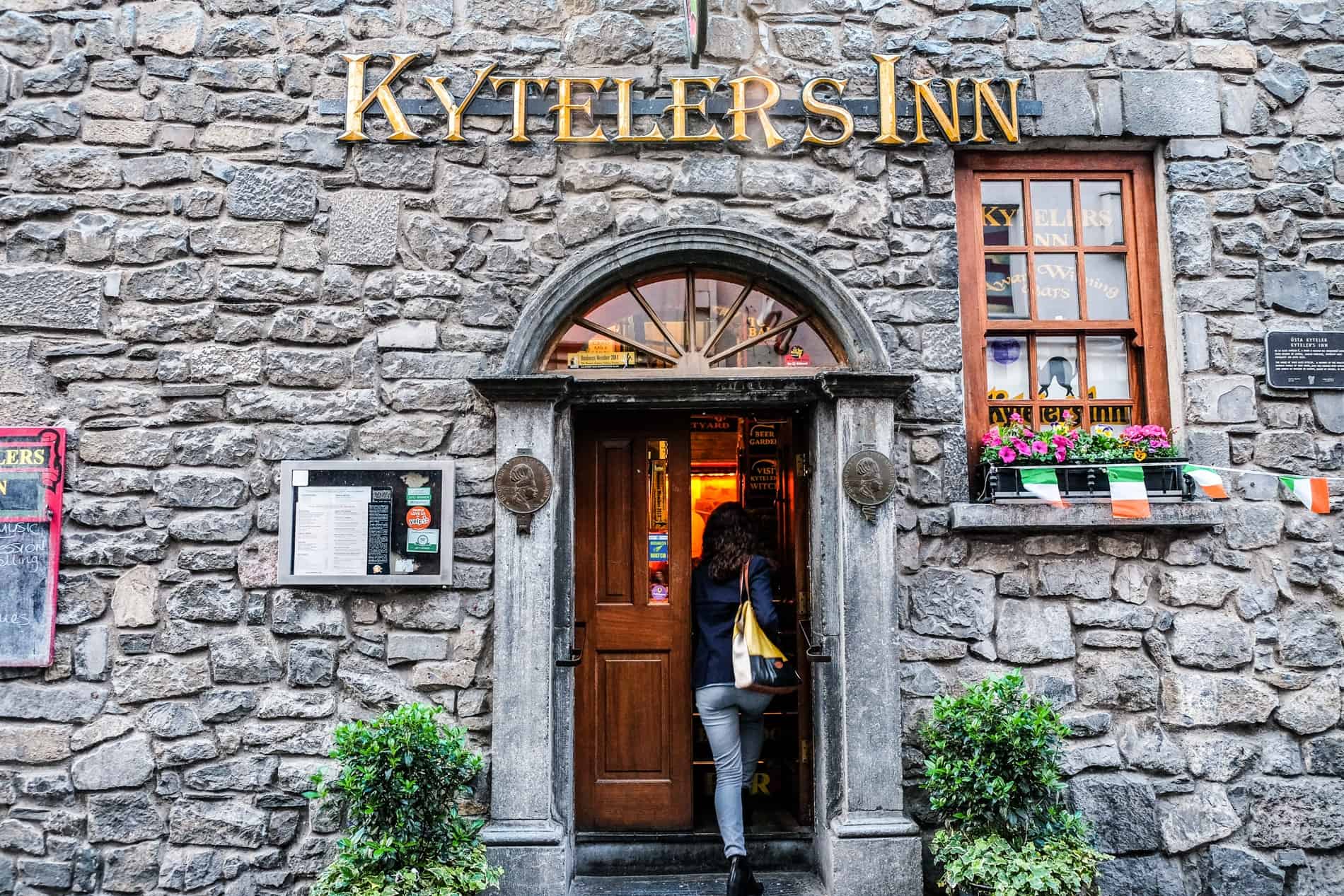 A woman walking into into the medieval building of the Kyteler's Inn - the oldest inn in Kilkenny. 