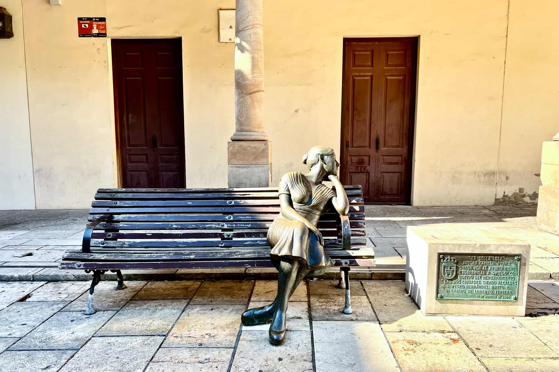 The 'La Bella Lola' statue in Oviedo of a lady sitting on the bench looking longingly to the distance. 