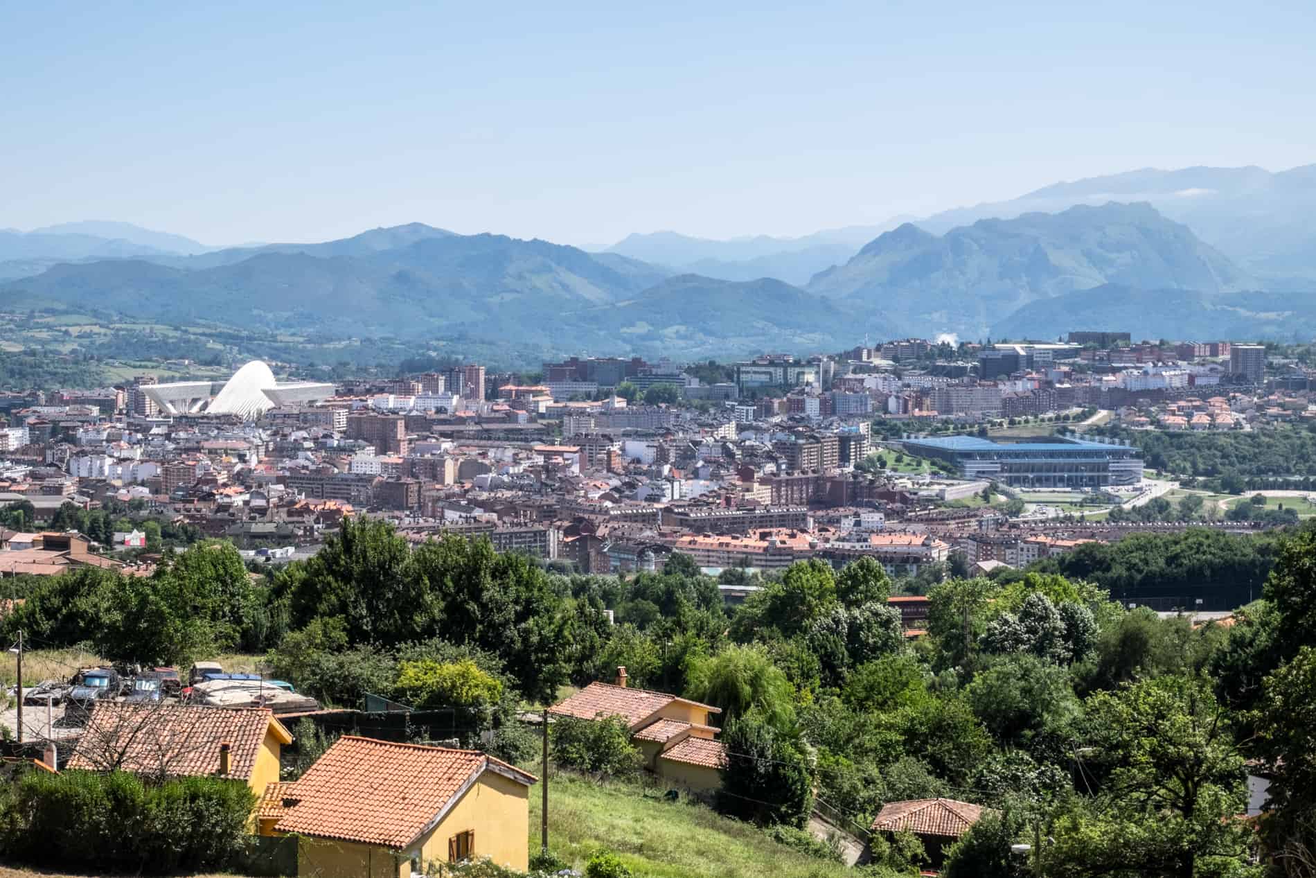 View from a hilltop overlooking Oviedo city in Spain, set within a basin surrounded by mountains. 