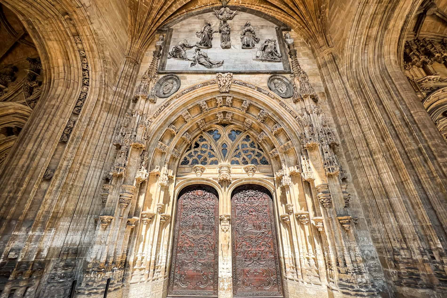 The intricate carvings and decor of the vaulted archway entrance of the Gothic Basilica del Salvador in Oviedo.