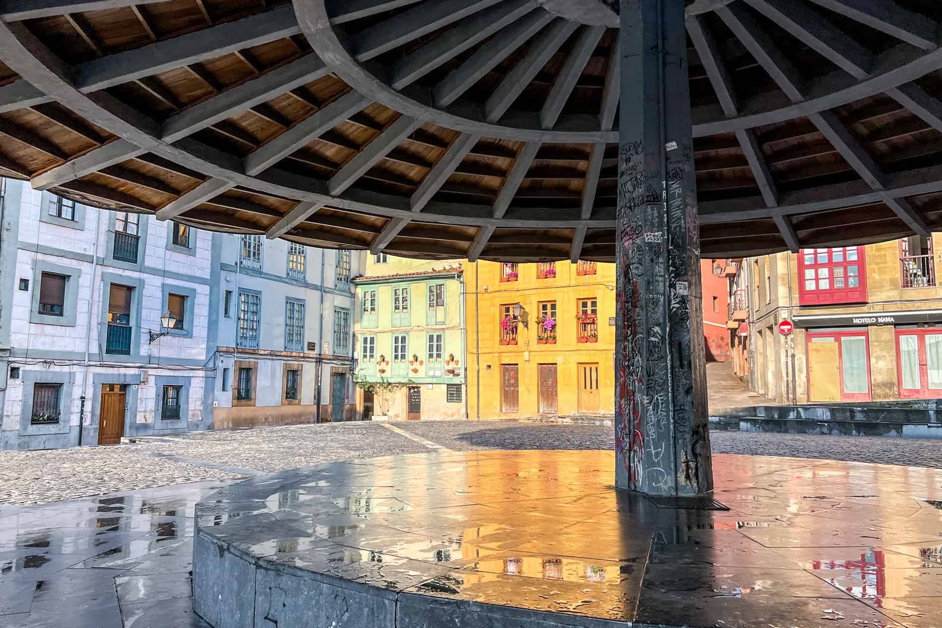 Colourful building poke out from beneath the structure of a giant umbrella in Oviedo, Spain. 