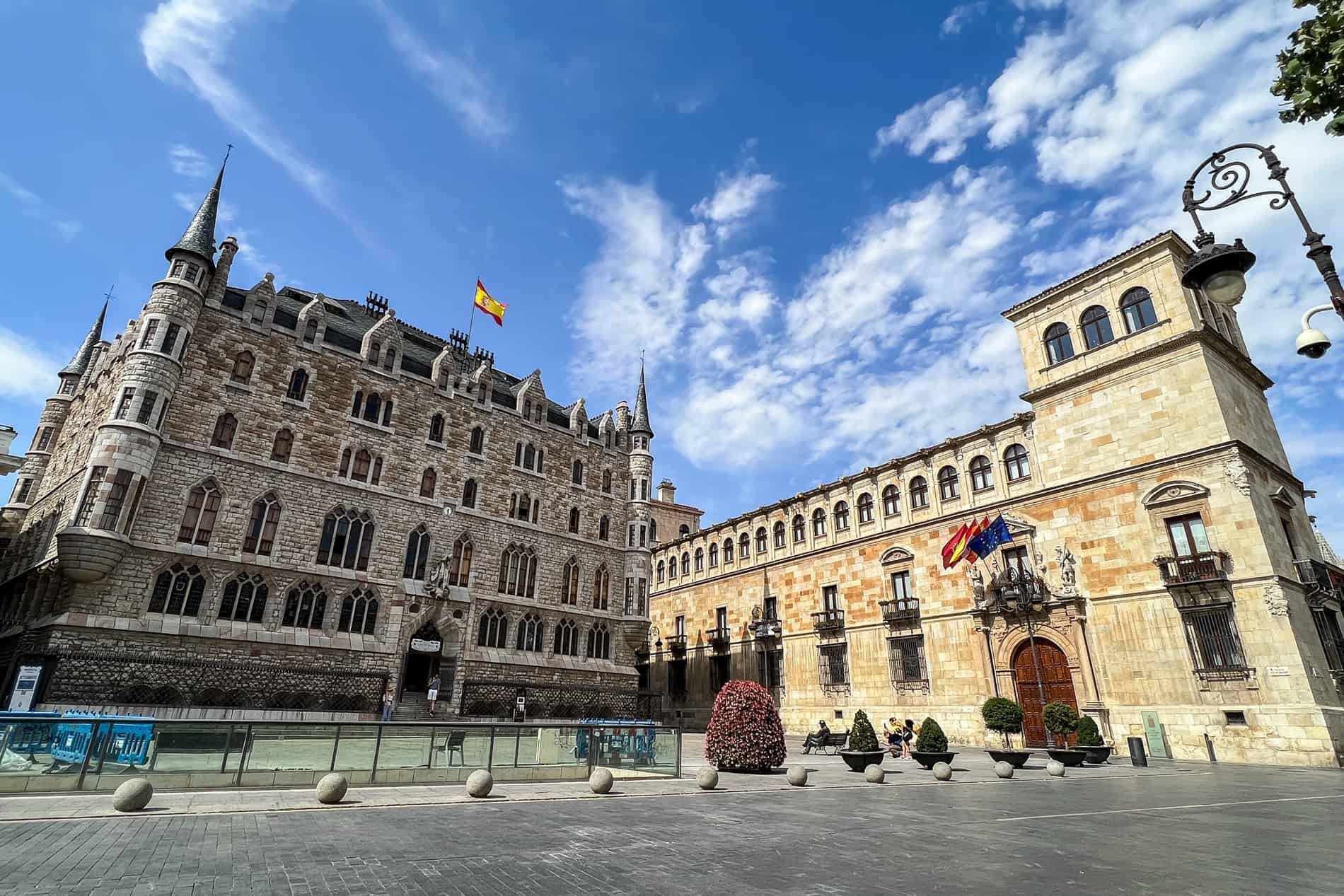 The castle style Casa Botines building on the left and the long, golden palace-type building of Palacio de Los Guzmanes on the right. 