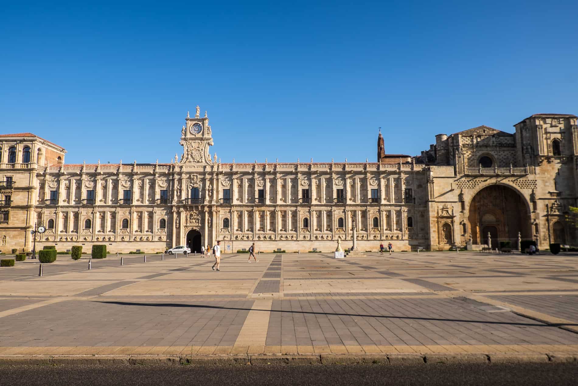 A long building with intricate carvings and a chapel on the right end; the Spanish Renaissance monument of Hostel de San Marcos Parador de León.