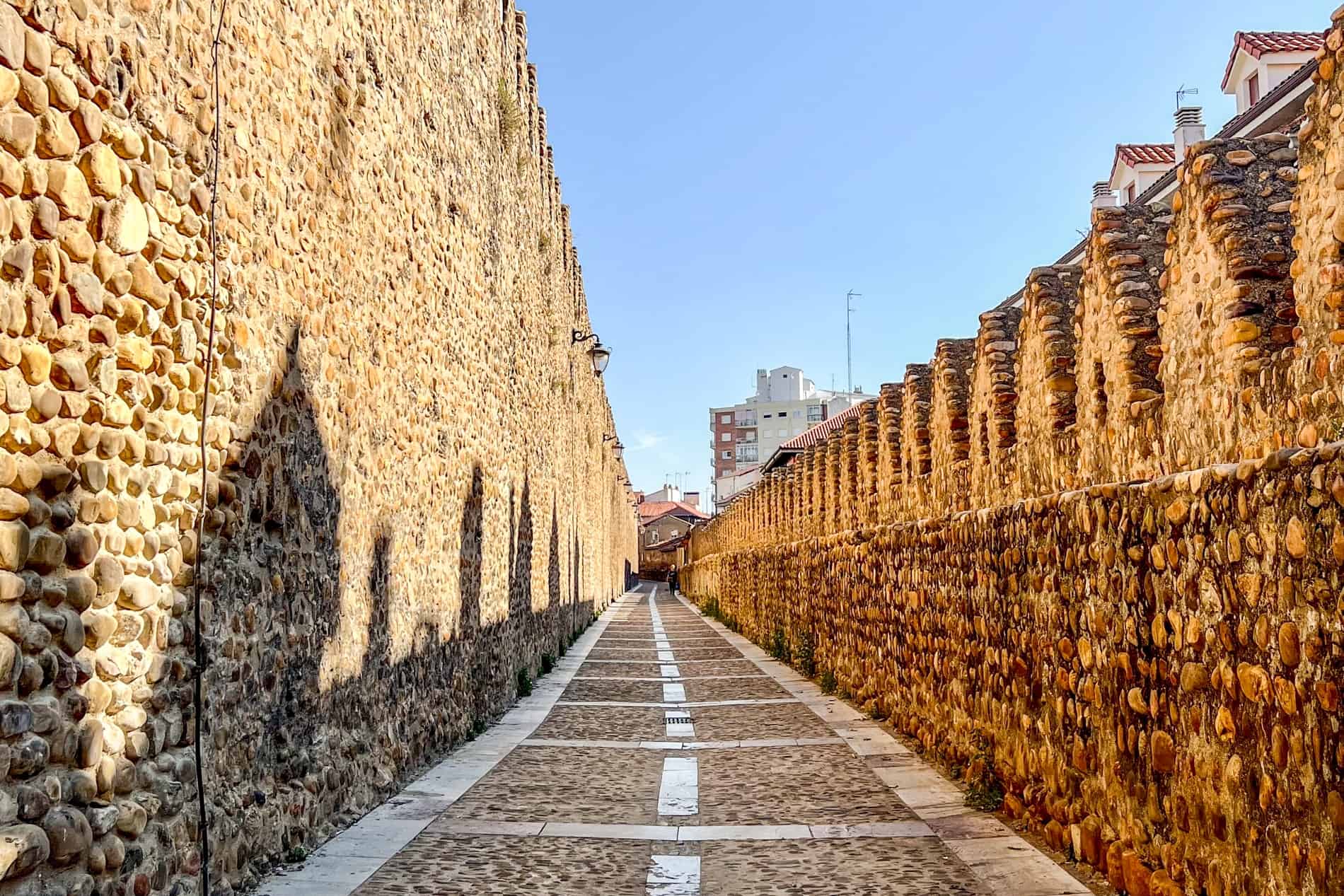 A cobblestone pathway lined by stone walls on either side - the Medieval Fence in León.