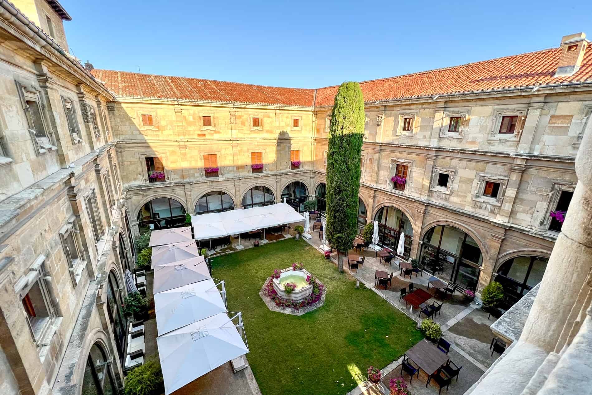 The golden stone arcade building and courtyard of the Hotel Real Colegiata San Isidoro in León.
