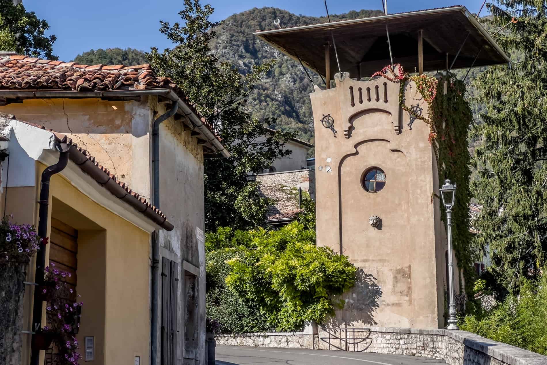 A mocha coloured tower structure on a road in the forest-set village of Cison di Valmarino in Italy. 