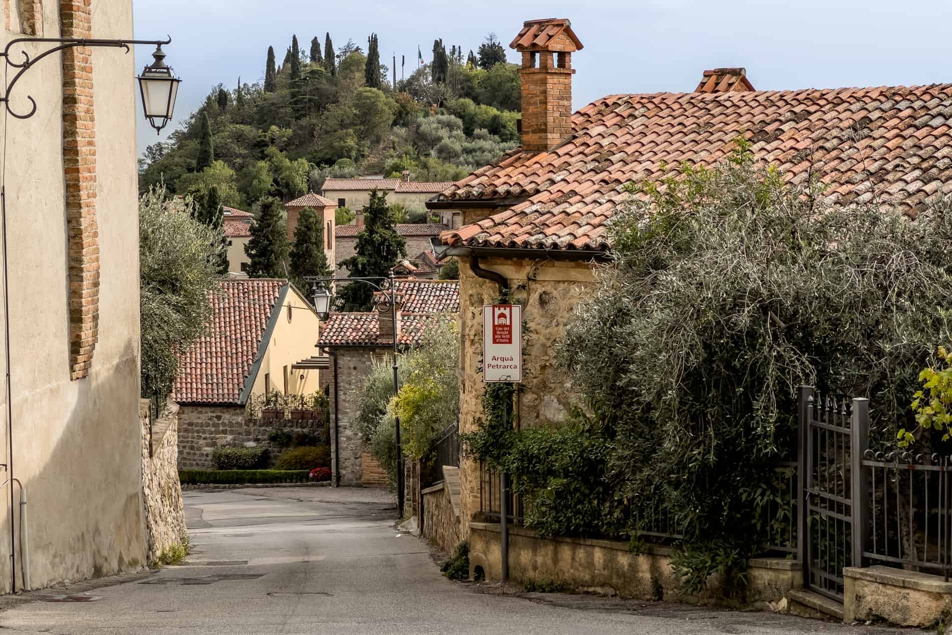 A cluster of orange roofed and yellow stones houses in Arquà Petrarca village in Italy. 