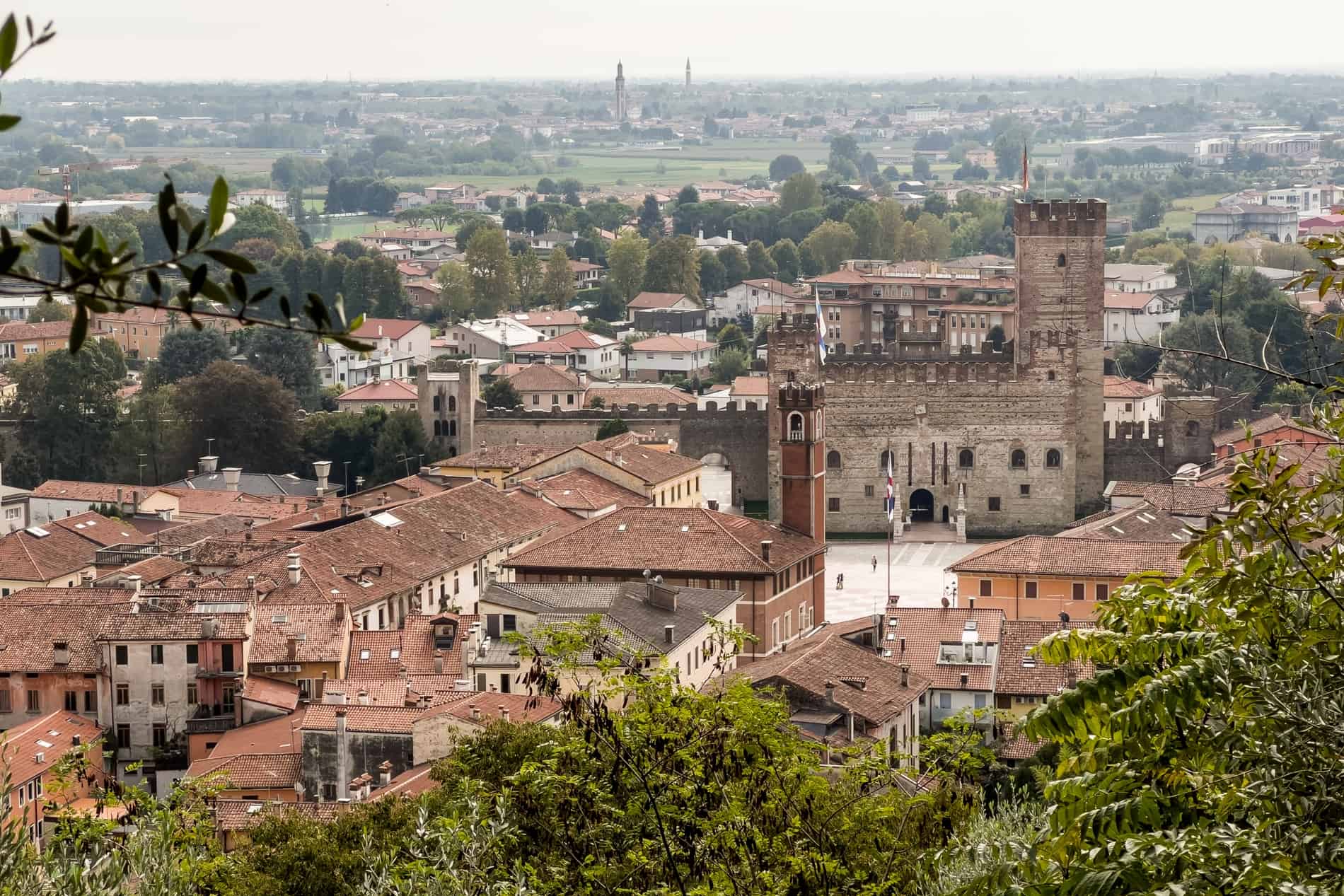 A castle structure in the middle of a cluster of small village buildings in Marostica, Italy.