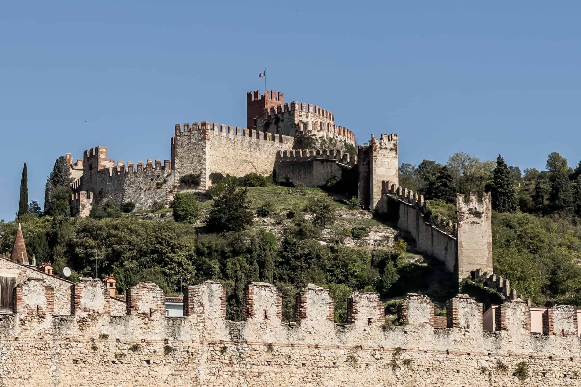 A medieval castle on a green hilltop in Italy's most beautiful village of Soave in Veneto. 