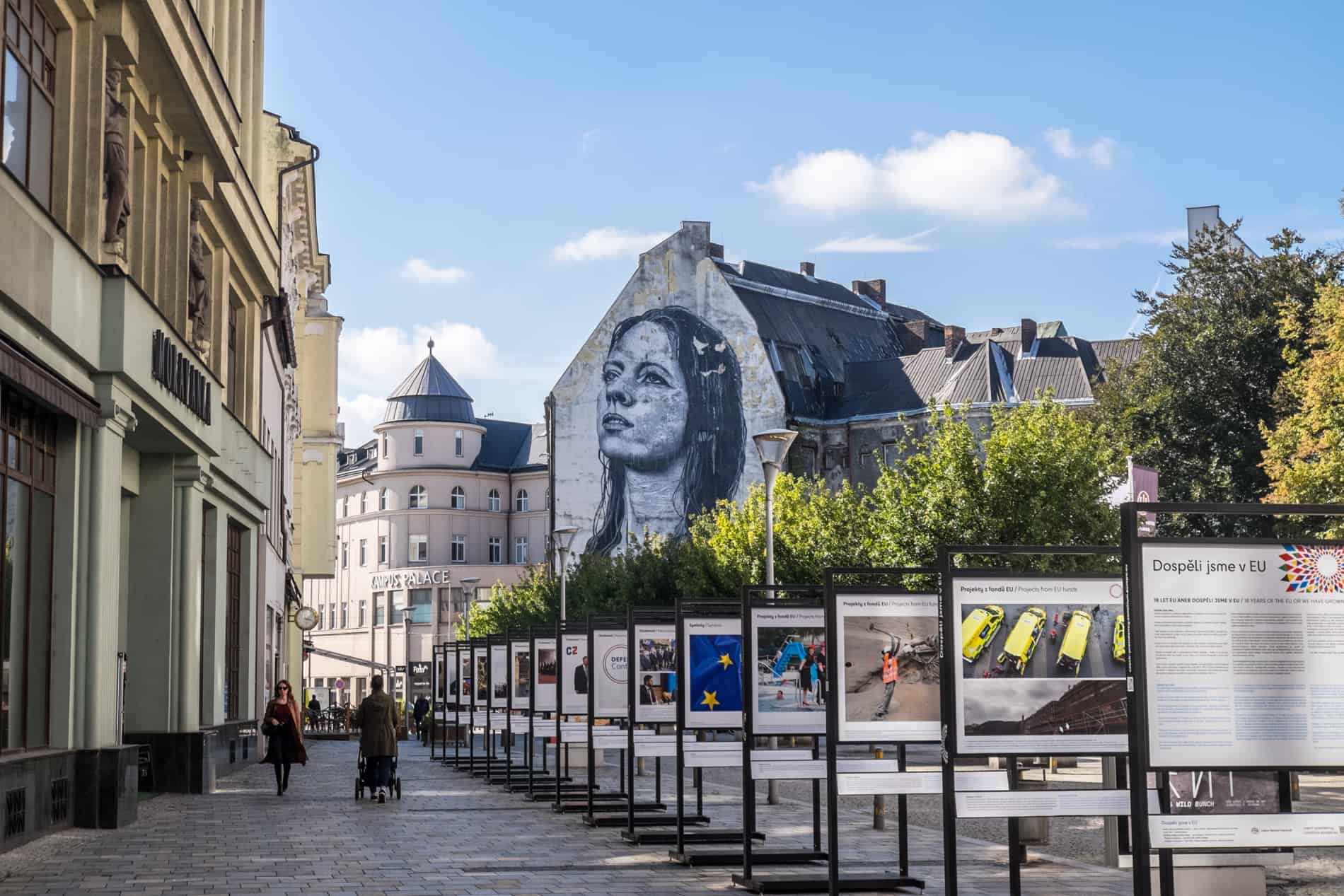 A mural of a woman on a building in Ostrava, at the end of a pedestrian street.