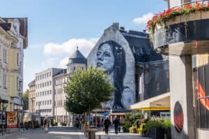 A mural of a woman on a building in Ostrava, at the end of a pedestrian street.