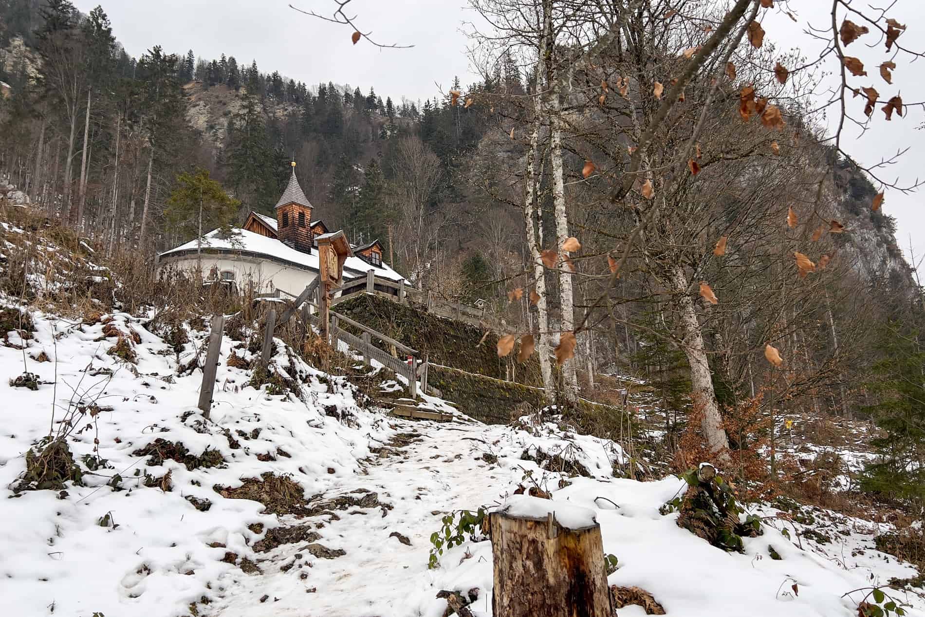 A tiny chapel perched in the snowy slopes of a forest in St. Johann in Tirol, Austria. 