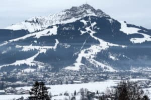 The Kitzbüheler Horn mountain in Austria covered in snow and ski slopes, rising above the village of St. Johann in Tirol.