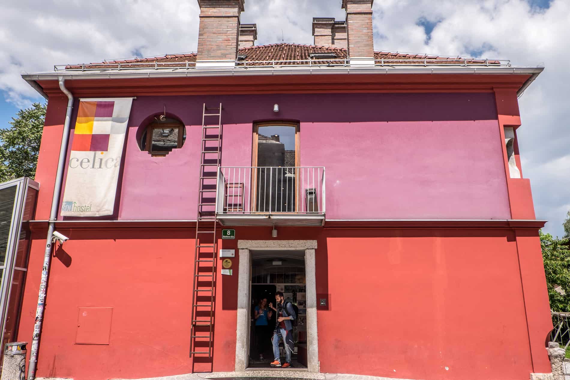 The pink and red building is a former prison turned Hostel Celica in Metelkova, Ljubljana.
