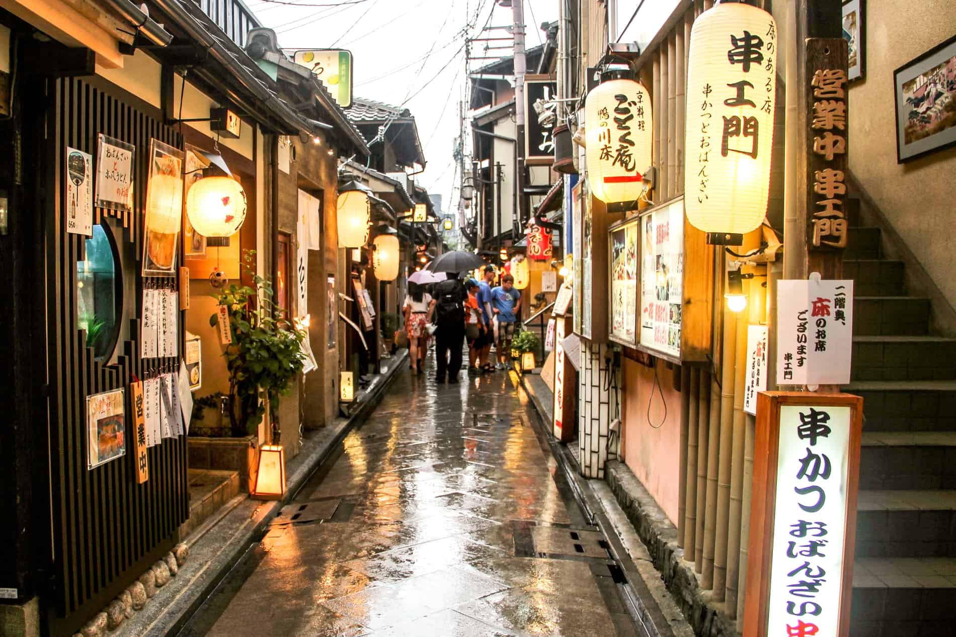 People in a narrow street of wooden houses and shops in Gion, Kyoto. 