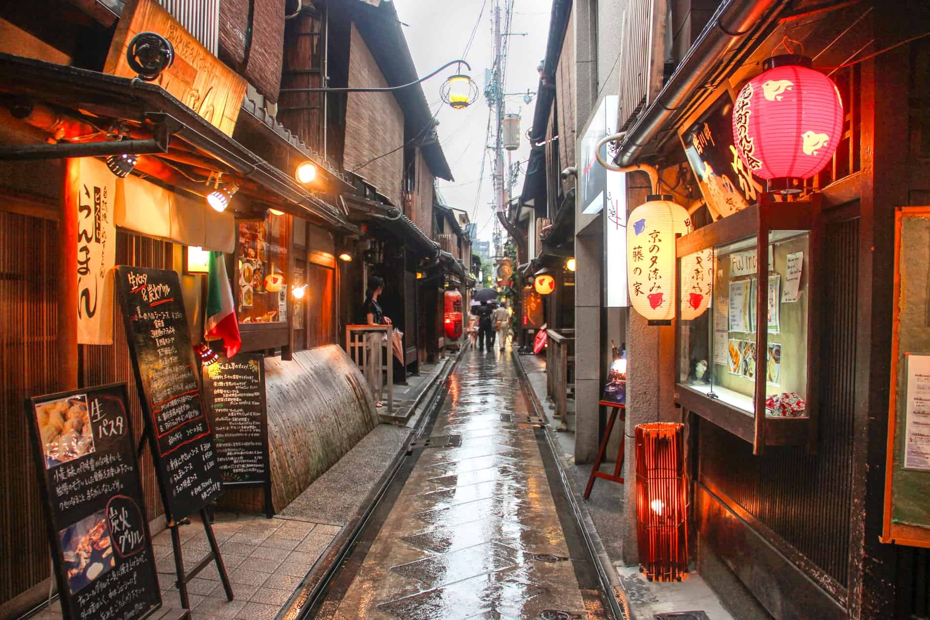 People in a narrow restaurant lined street in Gion, Kyoto.