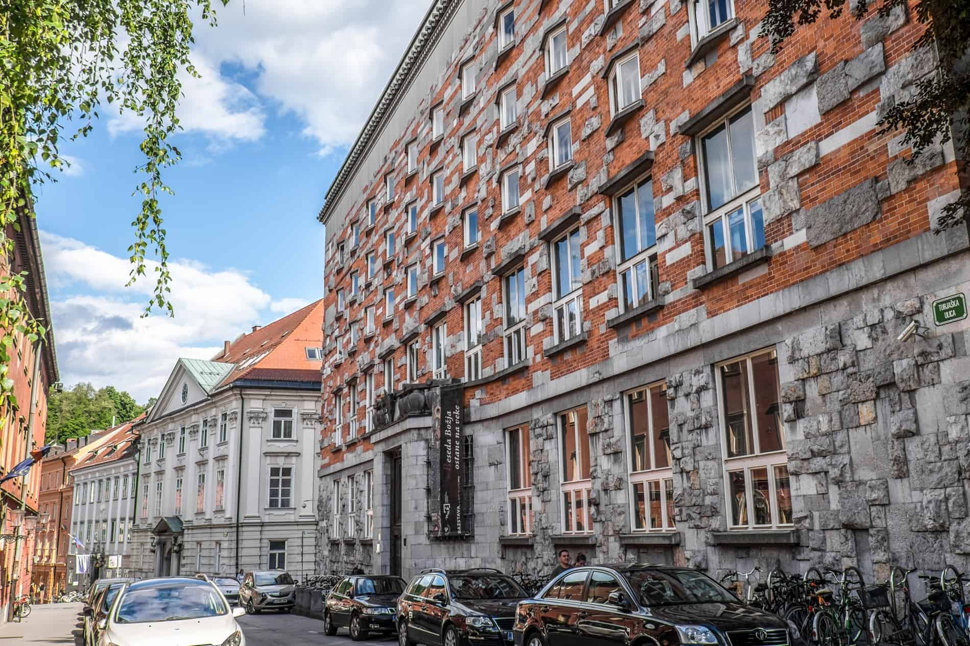 Red brick and silver stone exterior of the National and University Library in Ljubljana, Slovenia