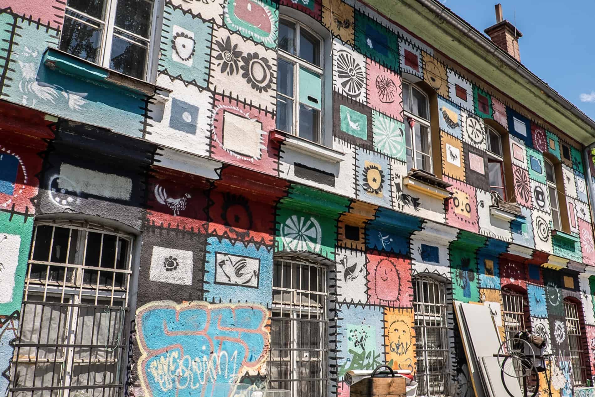 A building entirely painted in tile-style murals in Ljubljana's Metelkova art centre. 