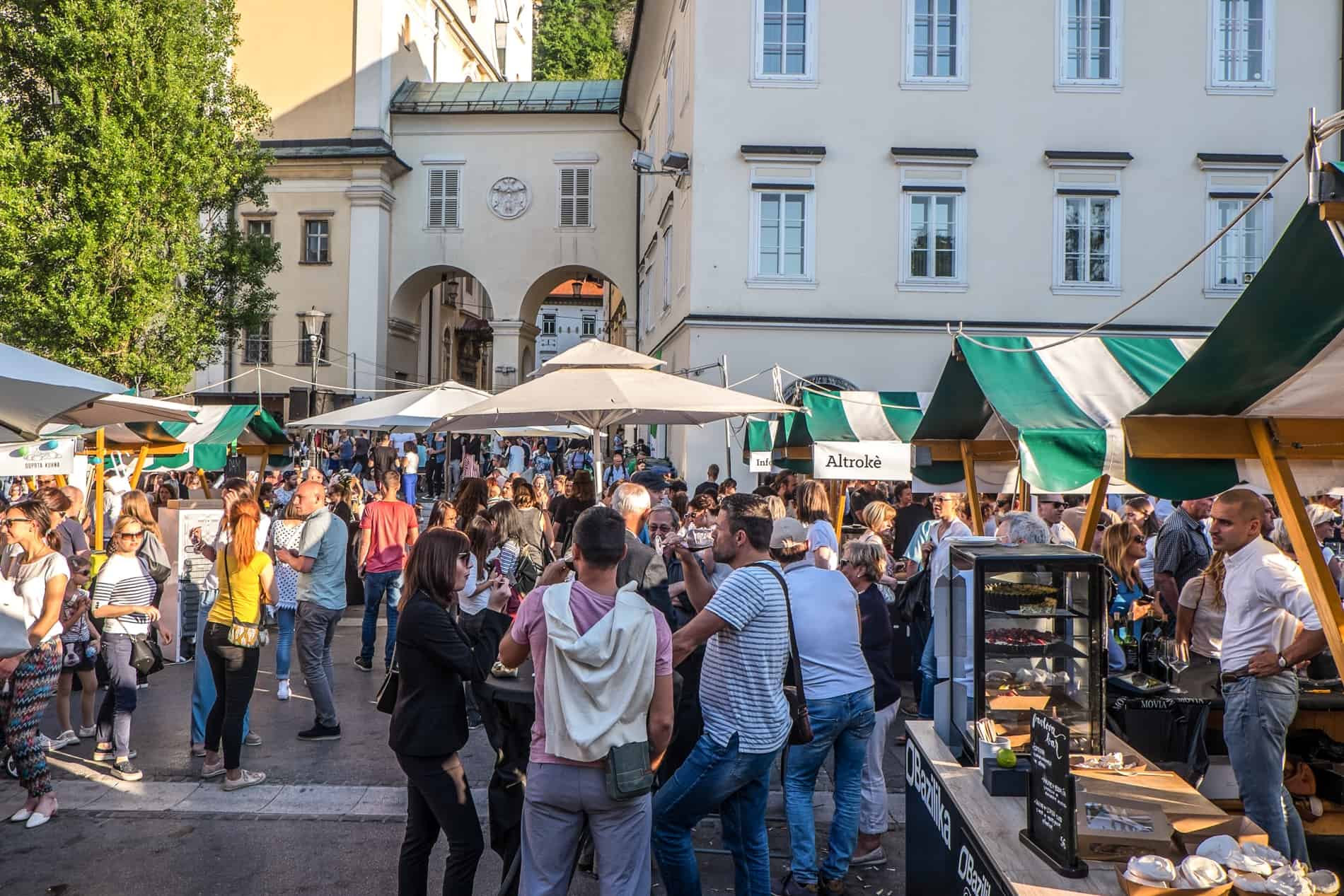 Crowds gather around stalls and tables at the Open Kitchen Market in Ljubljana every Friday.