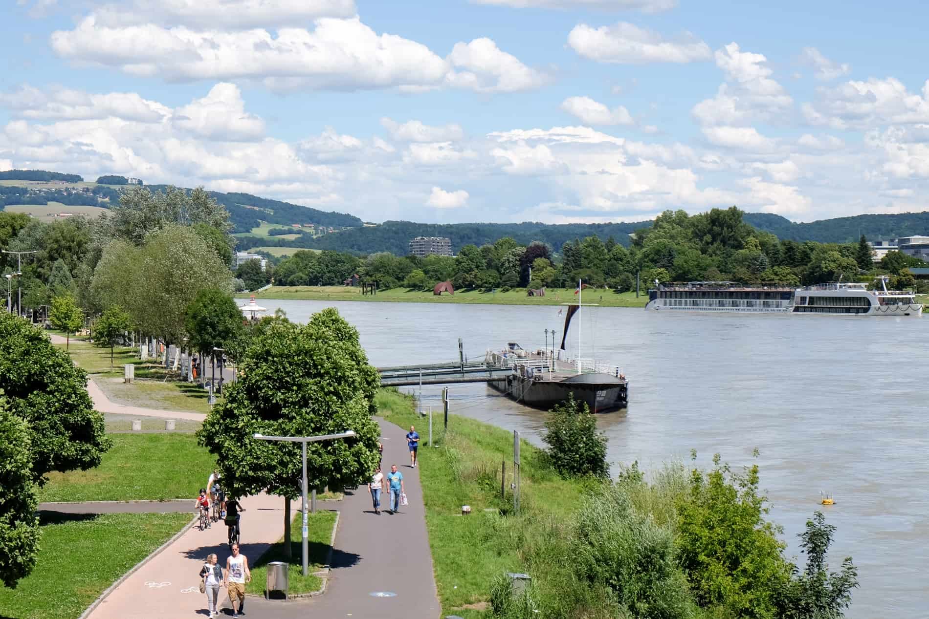 Green spaces, walking paths and docked boats on the Danube River in Linz, Austria. 