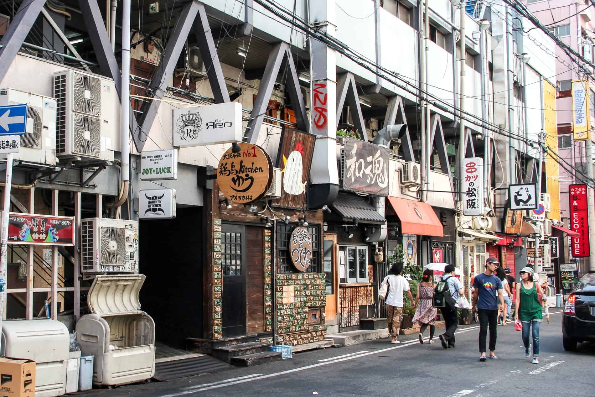 A street of restaurants in Shinsaibashi, Osaka with a mix of modern and traditional shop fronts. 