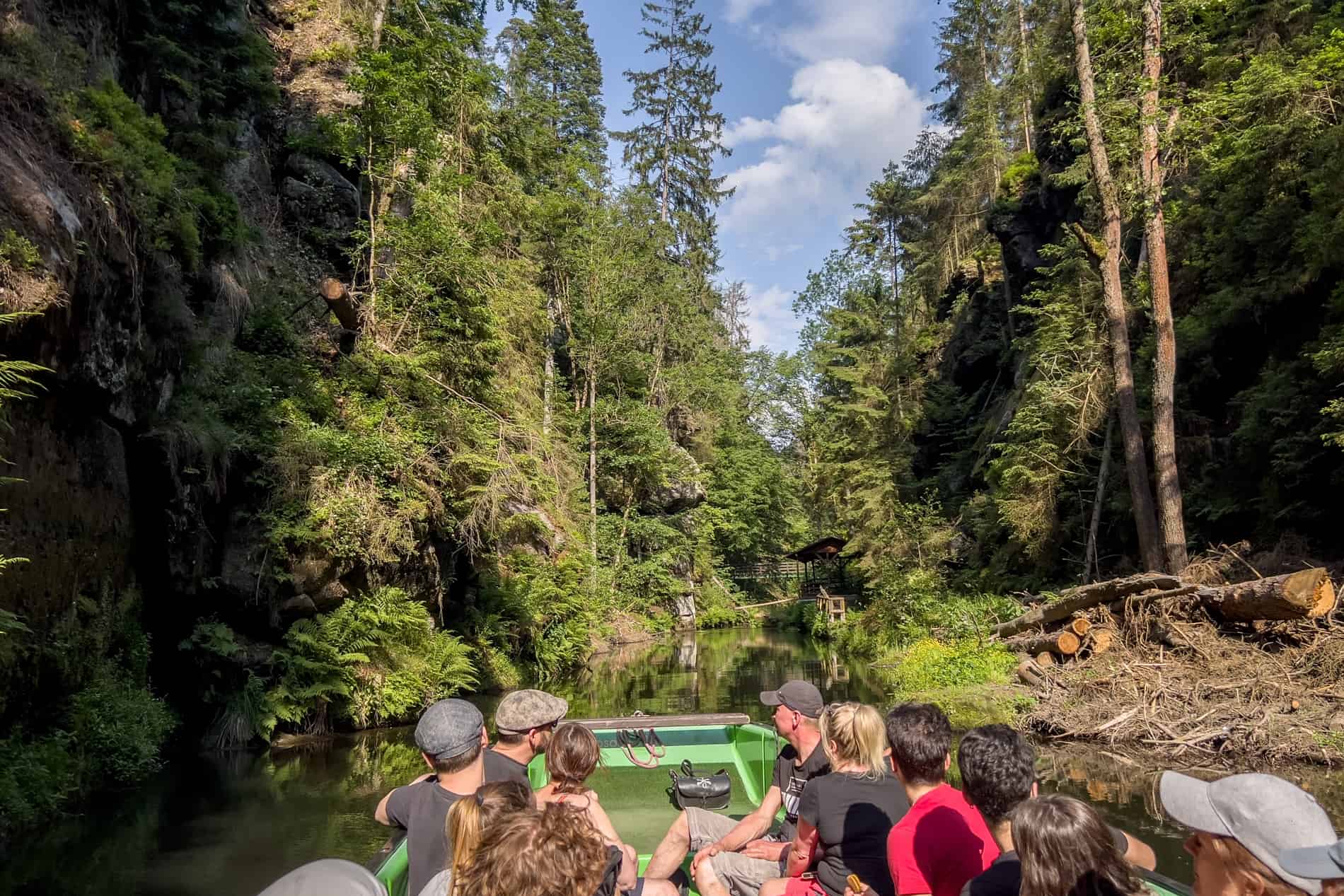 Visitors on a green boat, taking a trip on the Wild Gorge in Bohemian Switzerland. 