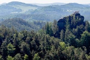 A viewing pavilion on top of a rock protruding from thick forest in Bohemian Switzerland, Czech Republic.