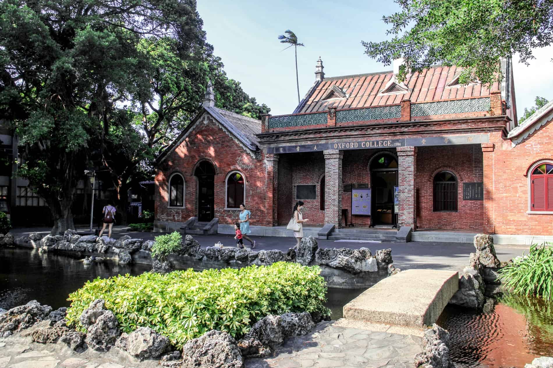 Visitors in the garden outside the red brick Oxford College of Alethia University in Taipei. 