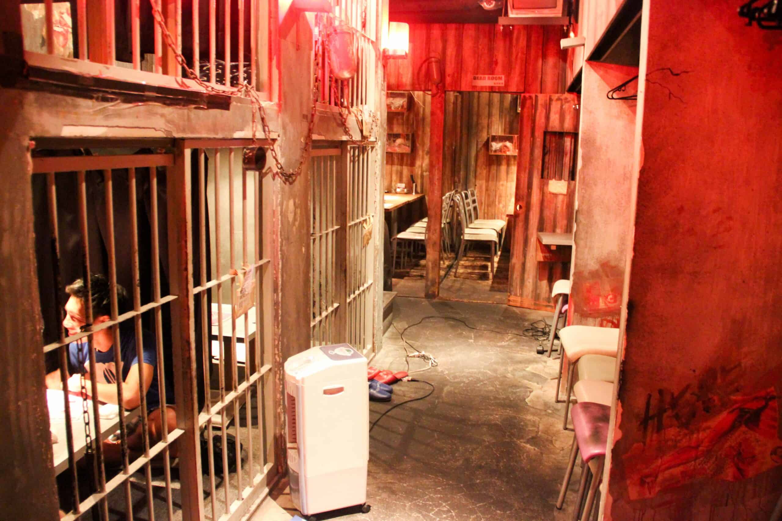 A man sits in a makeshift cell inside the red painted Alcatraz themed cafe in Tokyo, Japan.