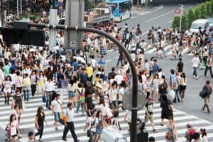 Hundreds of people on the large Shibuya Crossing pedestrian crossing in Tokyo.