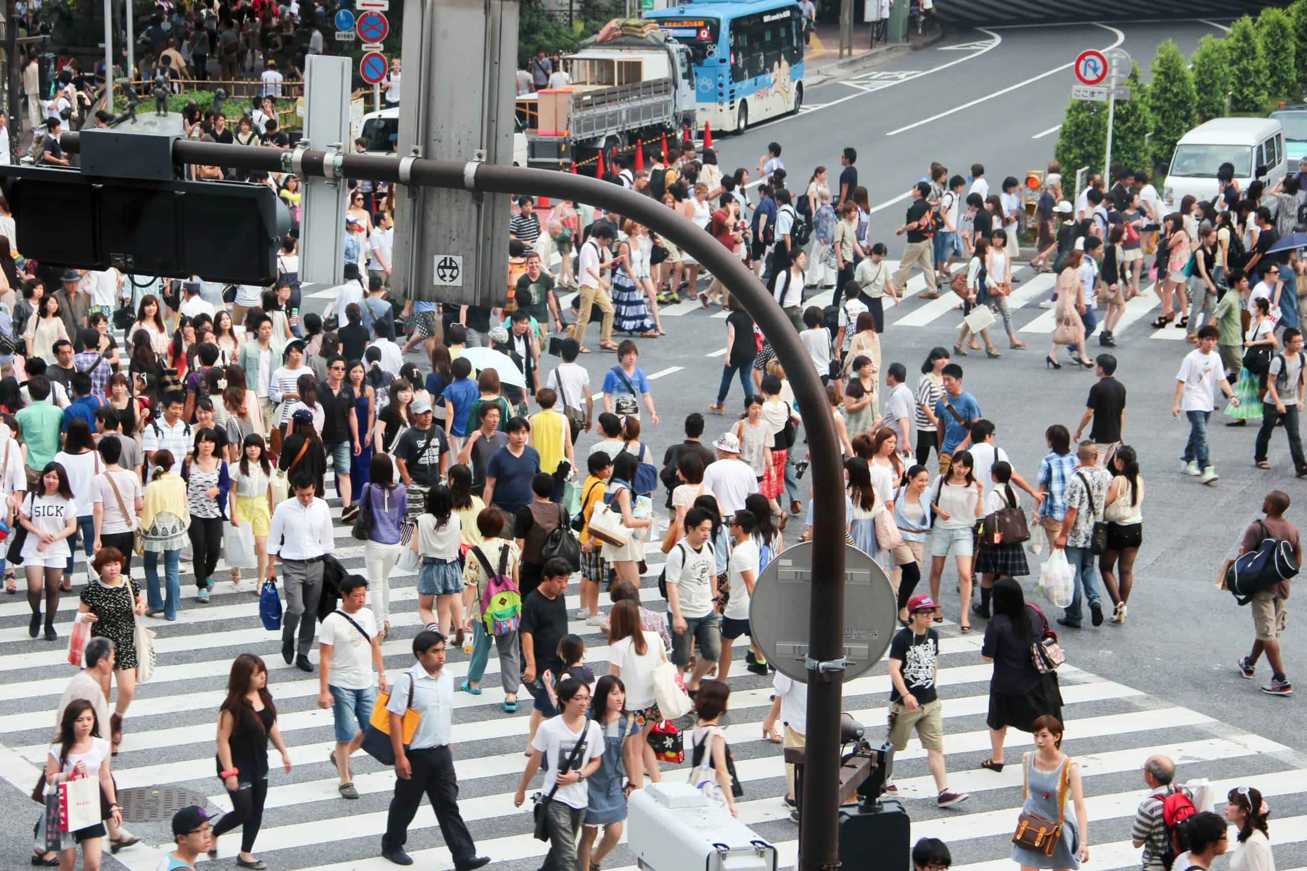 Hundreds of people on the large Shibuya Crossing pedestrian crossing in Tokyo.