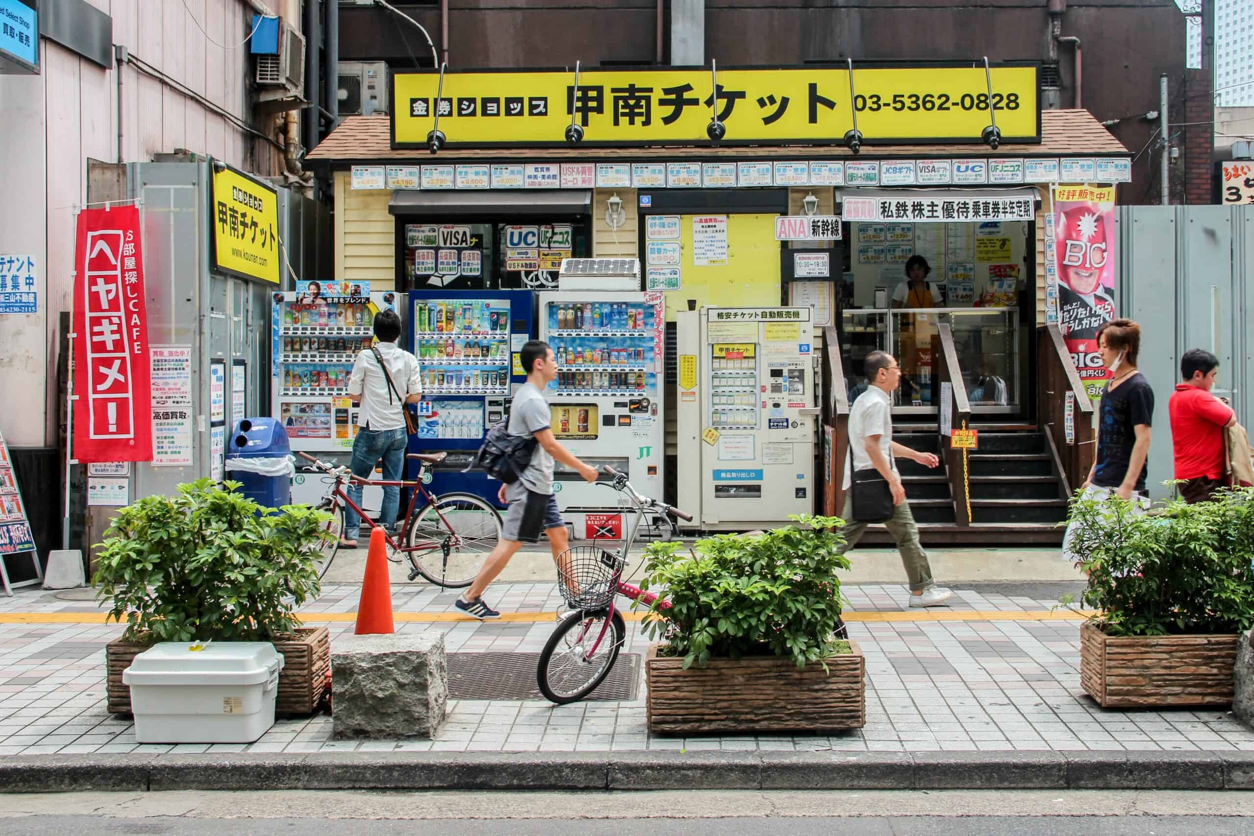 A man at one of a row of vending machines outside a lottery ticket shop in Tokyo, Japan. 