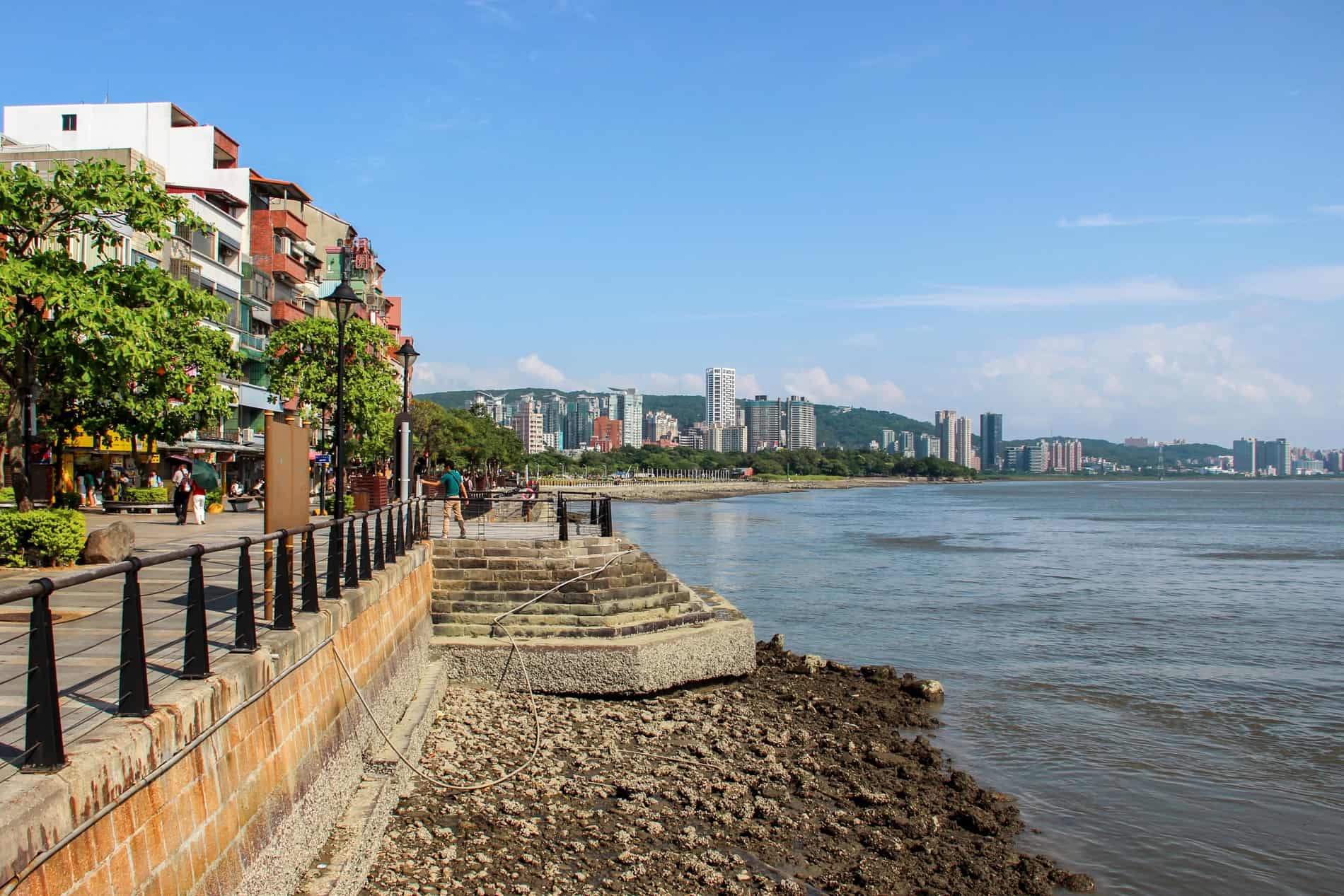 Modern apartments buildings line a small curve of coastline in Taipei. 
