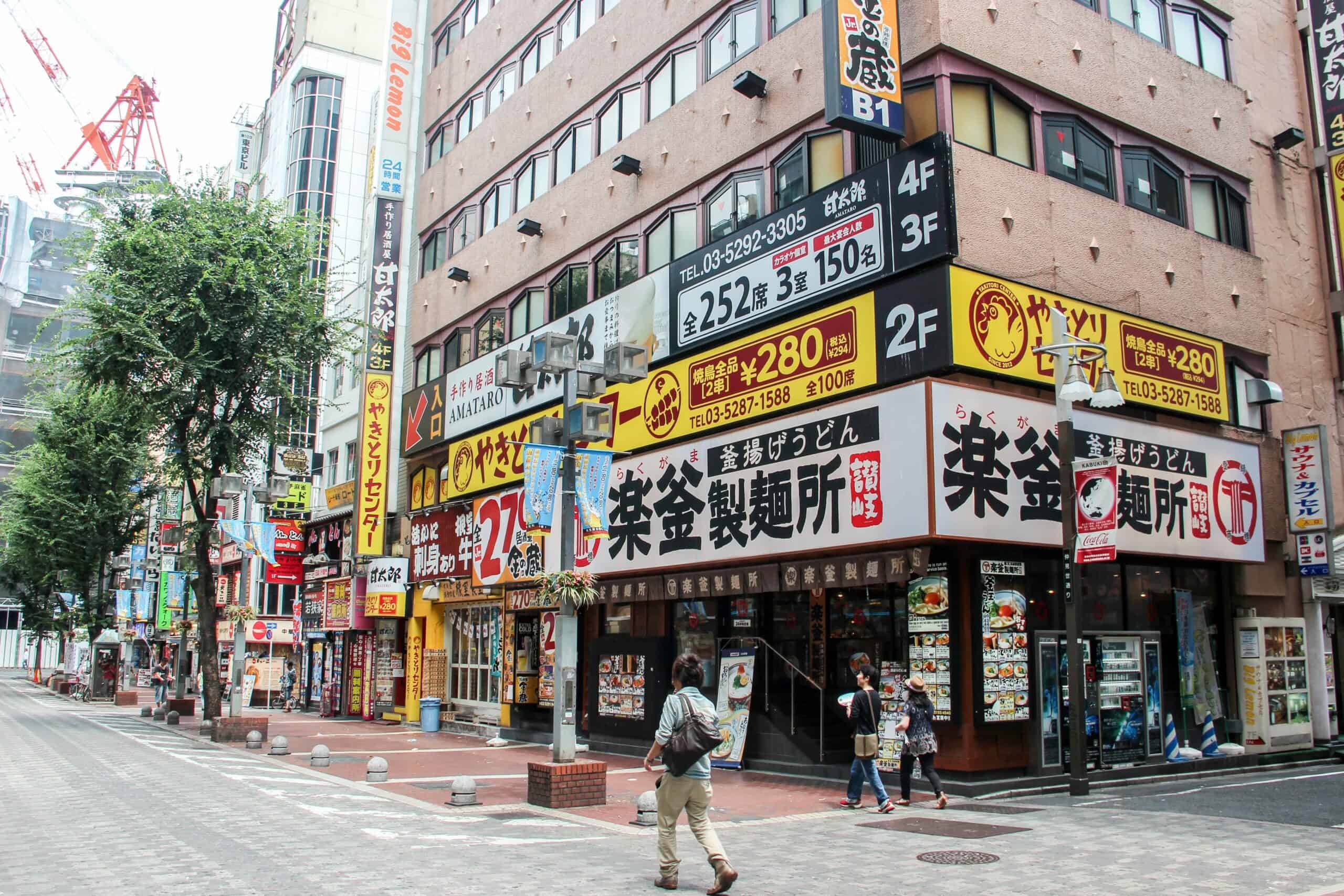 Overt black, white and yellow signage and advertising on buildings in Tokyo.