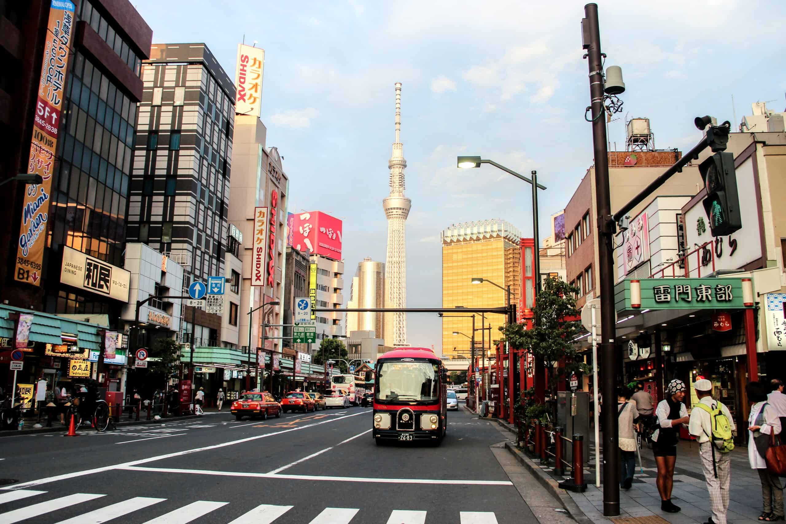 Main road in Tokyo with a bus on the road and the silver Tokyo Skytree tower in the background.
