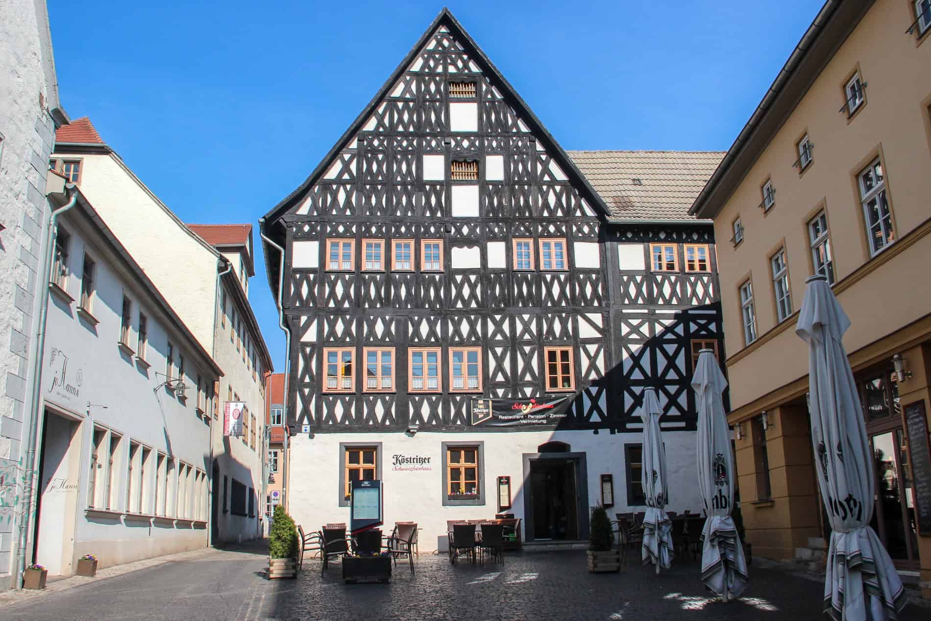 A white building with black thatch design and triangular roof. 