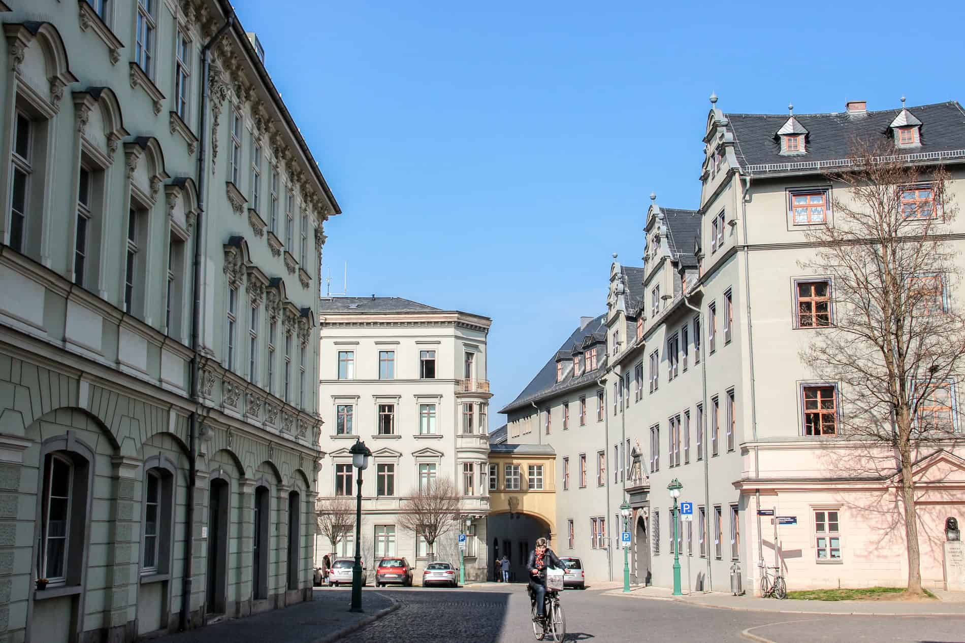 A woman on a bike riding through the baroque streets of Weimar in east Germany. 