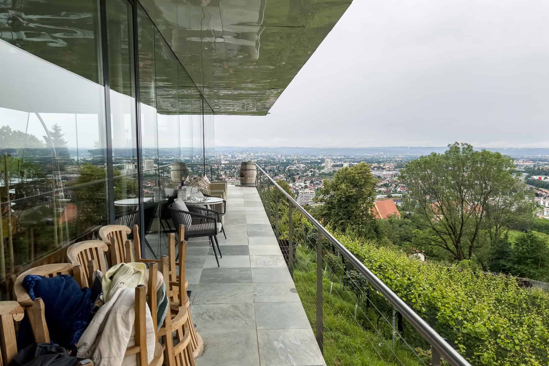 Balcony view over Graz city from a glass house on a vineyard slope.