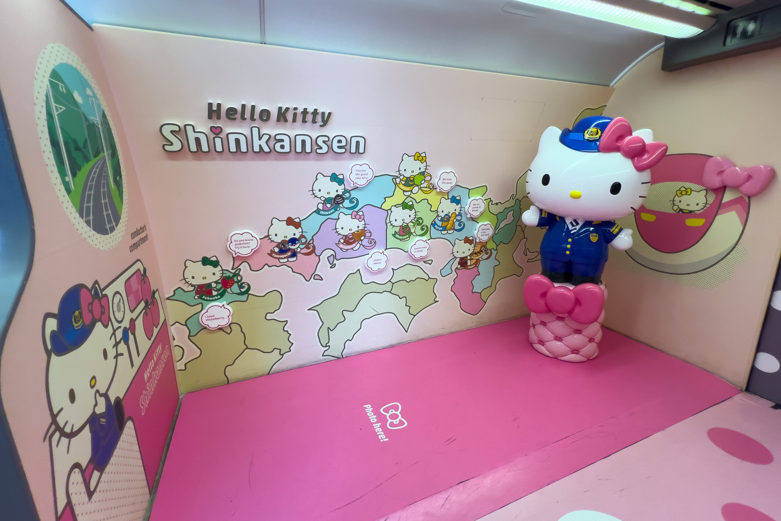 The photo corner on the Hello Kitty Shinkansen train featuring a giant Hello Kitty sculpture on a bright pink floor.