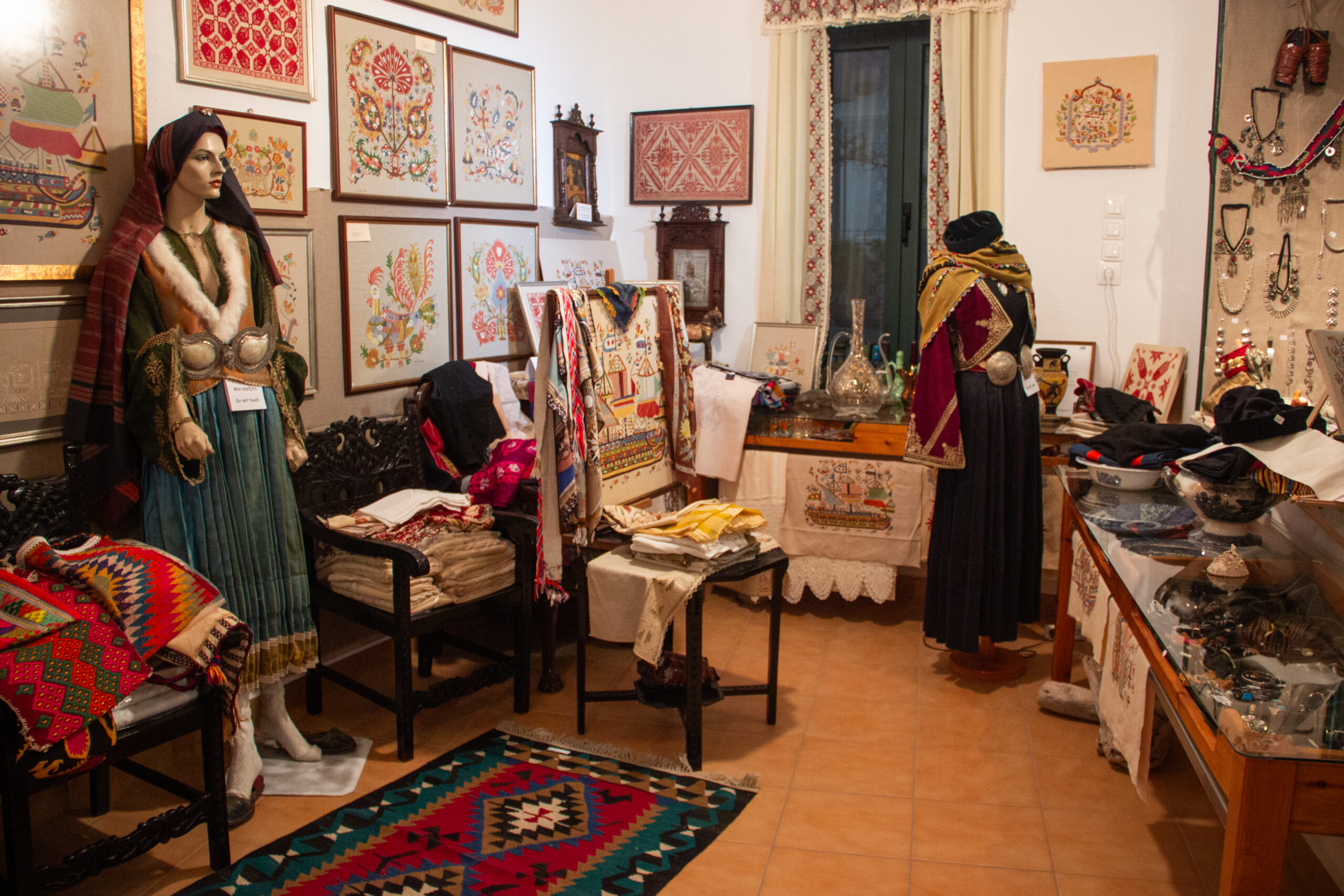 Interior of the Skyros Faltaits Museum room showcasing fabric design, traditional clothings and accessories.