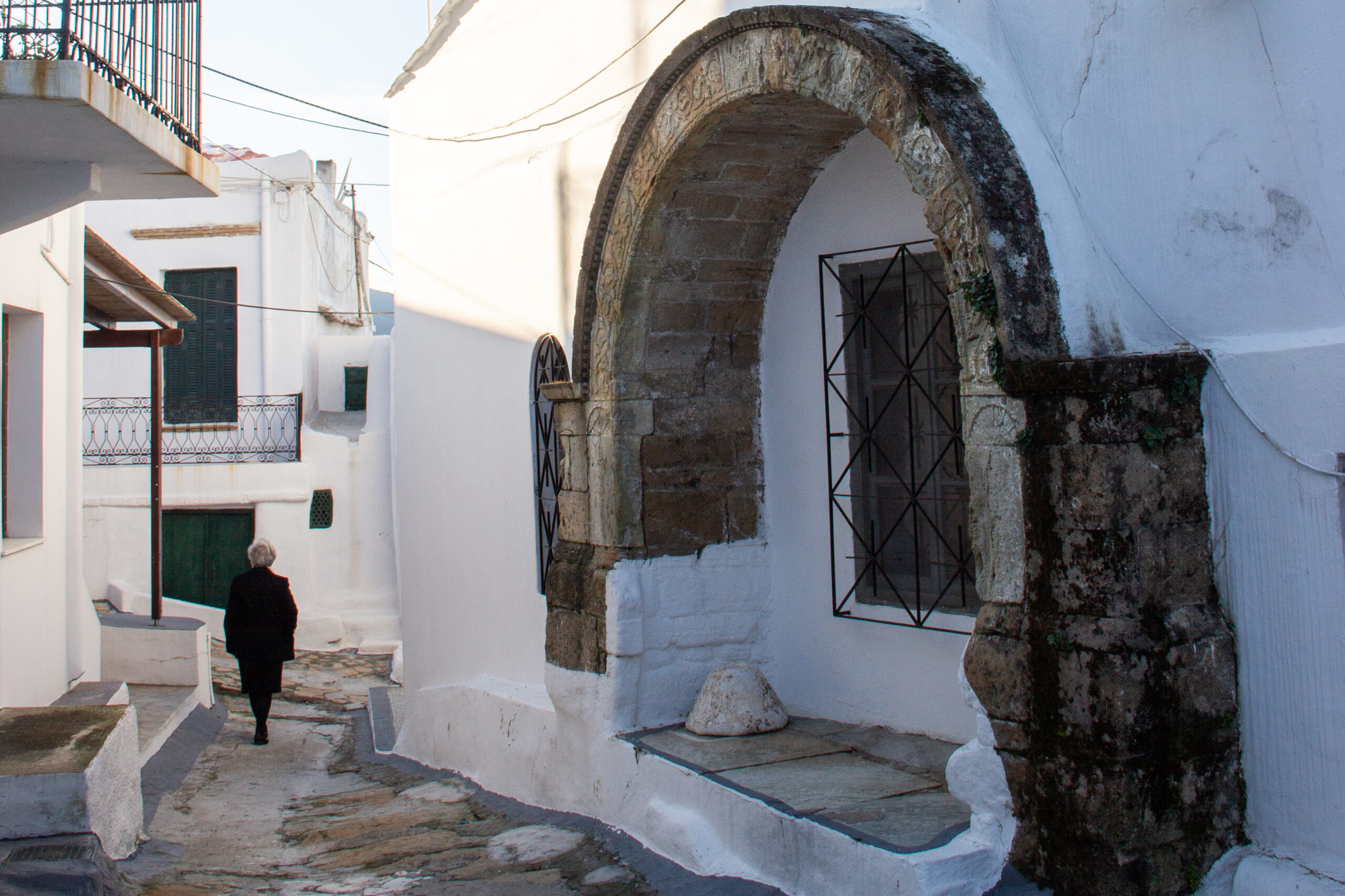 Skyros island town with white-washed walls, stone architecture and cobbled streets under a bright sky.
